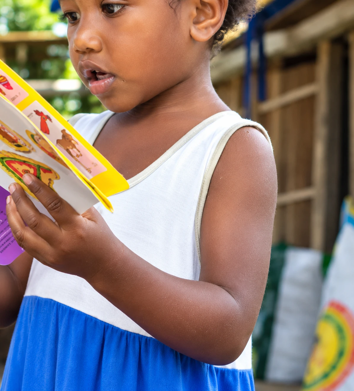 A young girl reading a picture book